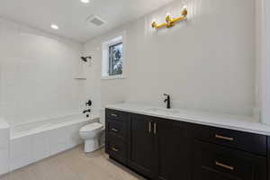 Full bathroom with vanity, toilet, and tiled shower / bath