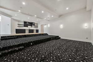 Carpeted home theater room featuring beam ceiling and Kitchenette