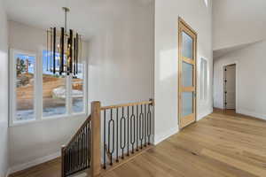 Hall with a chandelier and light hardwood / wood-style floors