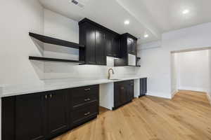 Theater Kitchen with sink and light hardwood / wood-style floors