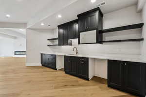 Theater Kitchen with sink and light hardwood / wood-style flooring