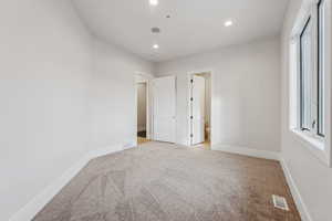 Unfurnished bedroom with light carpet and ensuite bath