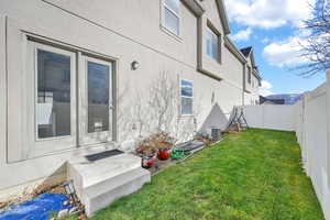 Rear view of house with a lawn and central AC unit