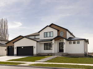 Modern farmhouse style home with a front lawn and a garage