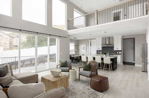 Living room with a high ceiling and light hardwood / wood-style flooring