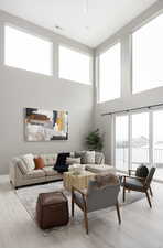 Living room featuring a water view, light hardwood / wood-style flooring, and a wealth of natural light