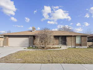 Ranch-style home with a front lawn and a garage