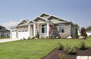 Craftsman-style home with a front yard and a garage