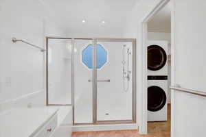 Ensuite Bathroom featuring a shower with door, and stacked washer and clothes dryer inside the walk in closet