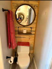 Bathroom featuring wood walls and toilet