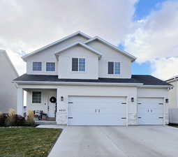 View of property featuring covered porch and a garage