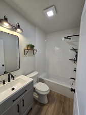 Full bathroom featuring vanity, hardwood / wood-style flooring, toilet, and tiled shower / bath combo