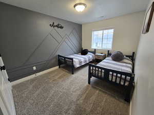 Carpeted bedroom featuring a textured ceiling