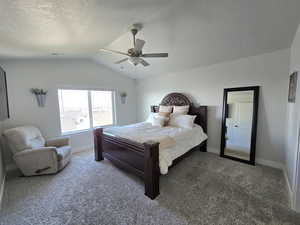 Carpeted bedroom with a textured ceiling, ceiling fan, and lofted ceiling