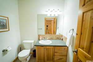 Bathroom featuring decorative backsplash, vanity, tile patterned floors, and toilet