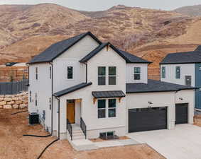 Modern inspired farmhouse with a garage, a mountain view, and central AC unit