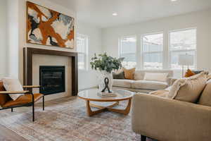 Living room with plenty of natural light, a fireplace, and light hardwood / wood-style floors