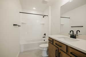 Full bathroom with tiled shower / bath combo, vanity, tile patterned floors, and toilet