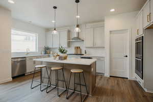 Kitchen featuring stainless steel dishwasher, white cabinets, and decorative light fixtures