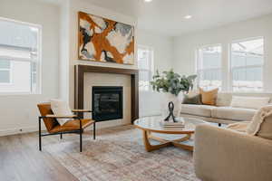 Living room with a healthy amount of sunlight, a fireplace, and light hardwood / wood-style floors