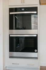 Interior details with stainless steel double oven and white cabinets