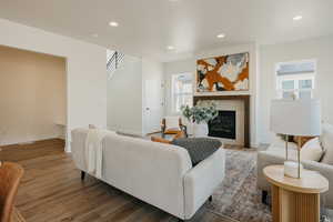 Living room with dark wood-type flooring and a fireplace