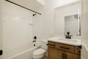 Full bathroom featuring vanity, tiled shower / bath, and toilet