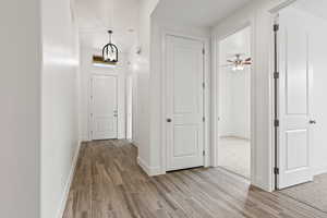 Hallway featuring a notable chandelier and light hardwood / wood-style floors