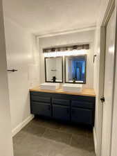 Bathroom with a textured ceiling and vanity