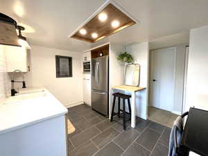 Kitchen featuring backsplash, wooden counters, white cabinets, sink, and stainless steel appliances