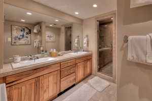 Bathroom with tile patterned flooring, vanity, and an enclosed shower