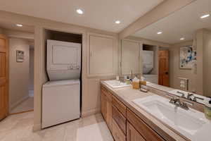 Bathroom featuring tile patterned floors, vanity, and stacked washer and clothes dryer