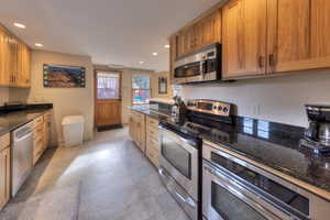 Kitchen with dark stone countertops and appliances with stainless steel finishes