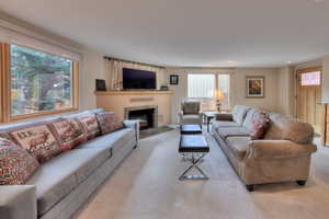 Living room with light carpet and a tiled fireplace