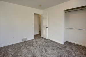 Unfurnished bedroom featuring carpet flooring and a closet