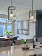 Kitchen featuring wood walls, a chandelier, and a textured ceiling