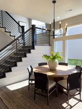 Dining space with wood-type flooring, a notable chandelier, and wood walls