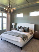 Bedroom with a raised ceiling, carpet flooring, wooden ceiling, and a notable chandelier