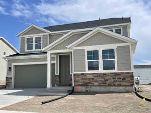 Craftsman-style house featuring driveway, a garage, stone siding, and roof with shingles