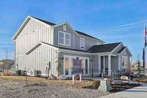 View of front of property with ac unit and french doors