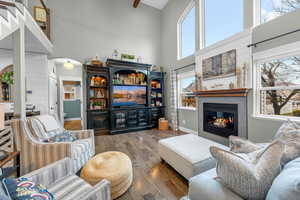 Great room featuring a fireplace, a towering ceiling, and hardwood / wood-style flooring