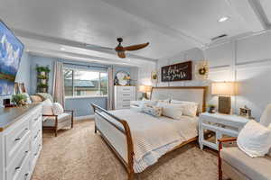 Bedroom featuring beamed ceiling, ceiling fan, light colored carpet, and a textured ceiling