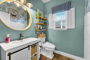 Bathroom with hardwood / wood-style floors, vanity, and toilet