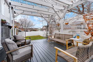 Wooden terrace with a pergola and an outdoor living space