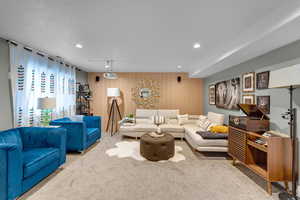 Carpeted living room with wooden walls