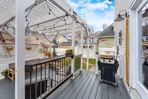 Wooden terrace featuring a pergola and grilling area