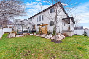 Back of property featuring a lawn and a pergola