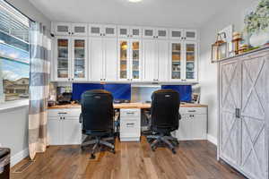 Office area featuring built in desk and light hardwood / wood-style flooring