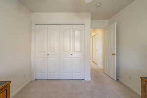 Unfurnished bedroom featuring a closet and light colored carpet