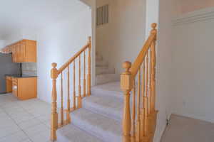 Staircase featuring tile patterned flooring and ornamental molding